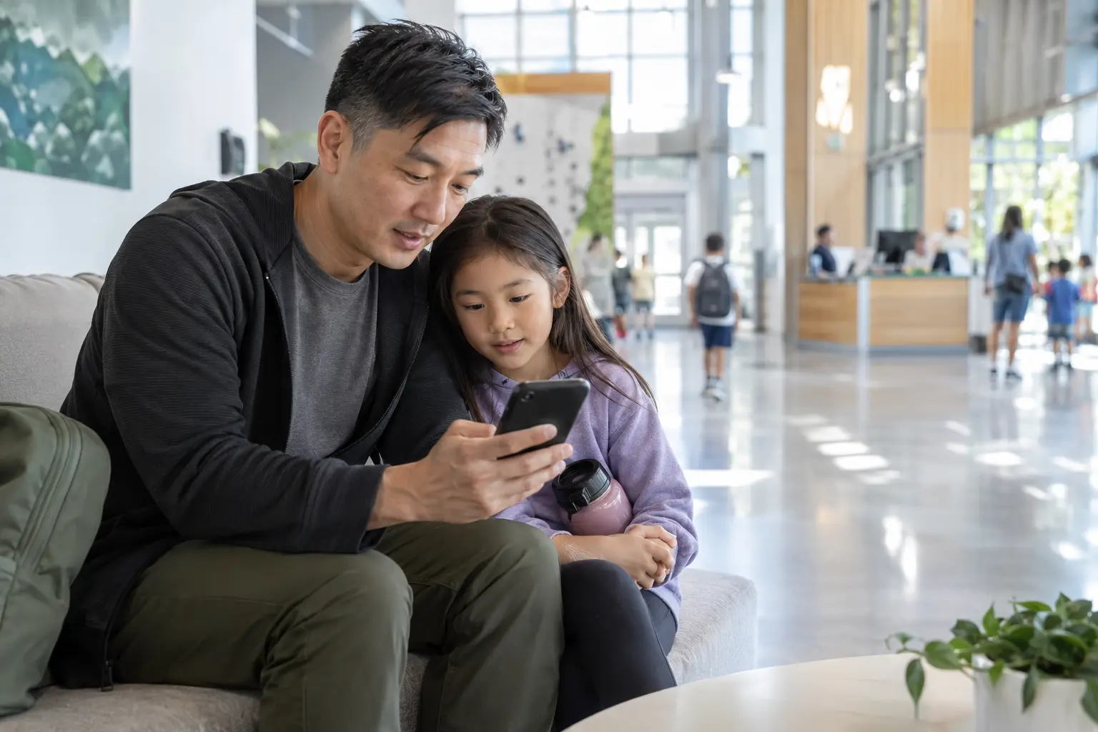 A parent and child choosing a recreation program together in a bright community center