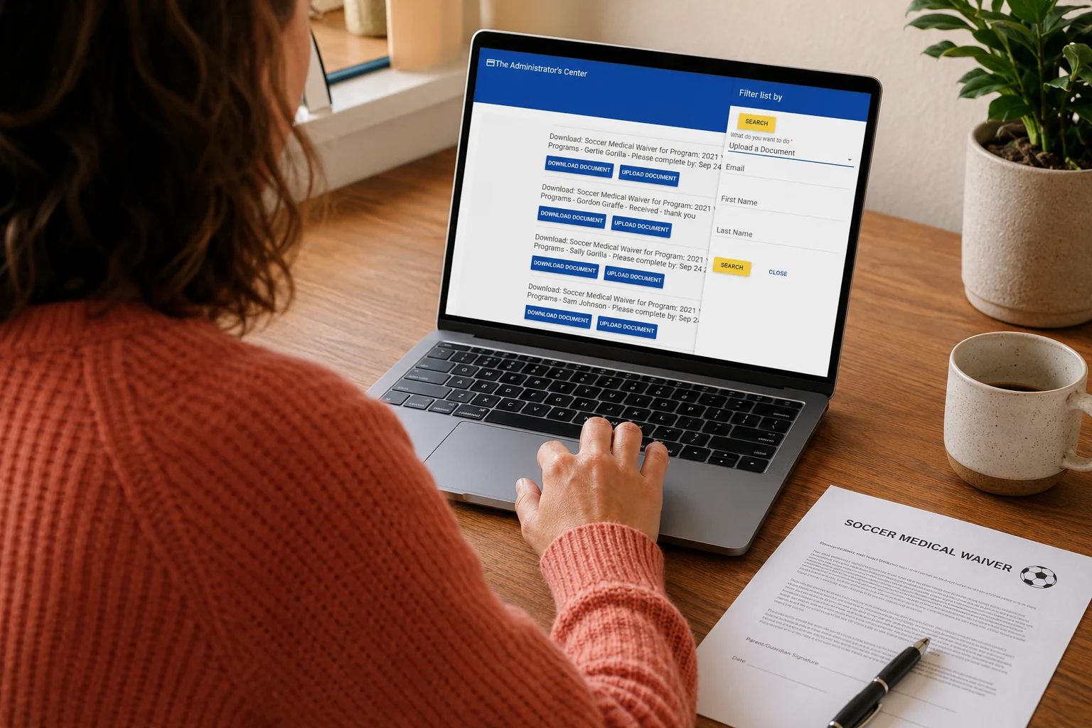 A staff member reviewing participant documents on a laptop beside a printed waiver